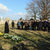 Menschen lauschen auf dem Friedhof einem Pastor