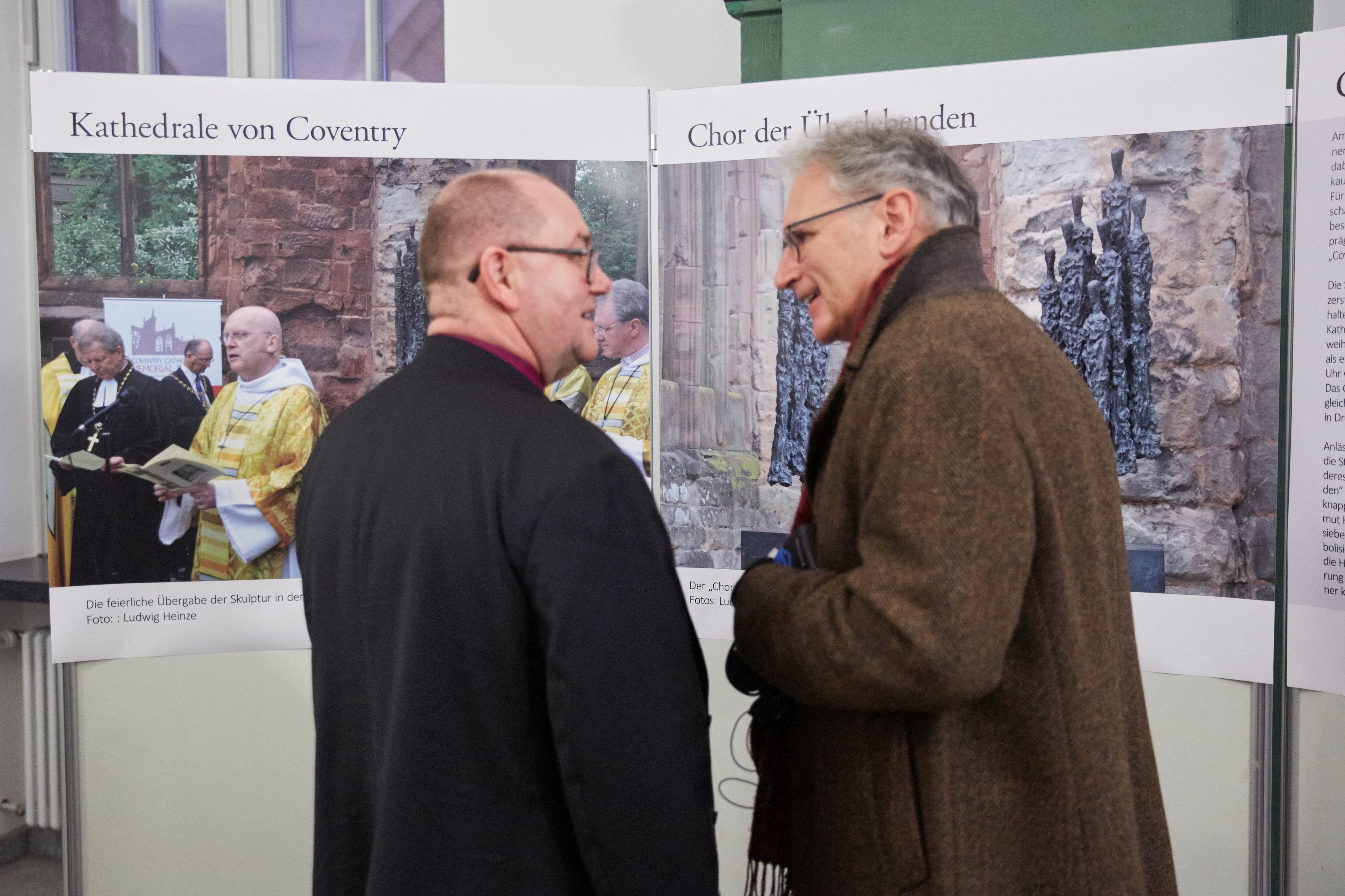 zwei Männer vor Ausstellungstafeln zu Coventry