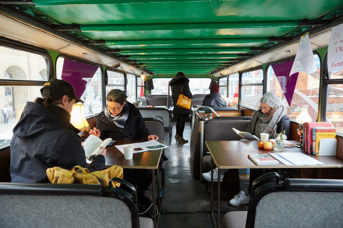 Blick in Bus mit Tischen und Sitzbänken