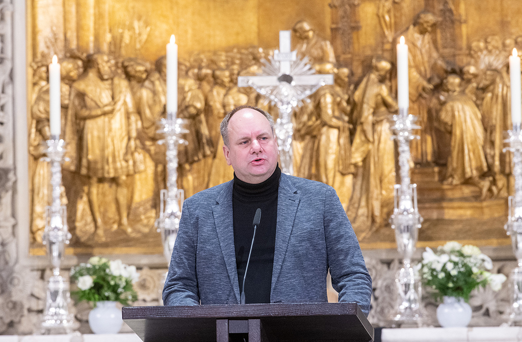 Oberbürgermeister Dirk Hilbert steht an einem Rednerpult in der Kreuzkirche, hinter ihm ist der Altar mit Kerzen in silbernen Leuchtern