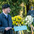Ein Mann spricht an einem Rednerpult, im Hintergrund stehen Blumengebinde