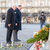 Oberbürgermeister Dirk Hilbert und CDU-Fraktionsvorsitzender Peter Joachim Krüger stehen vor einem Denkmal auf dem Altmarkt in Dresden, darauf stehen Blumenkränze und Kerzen