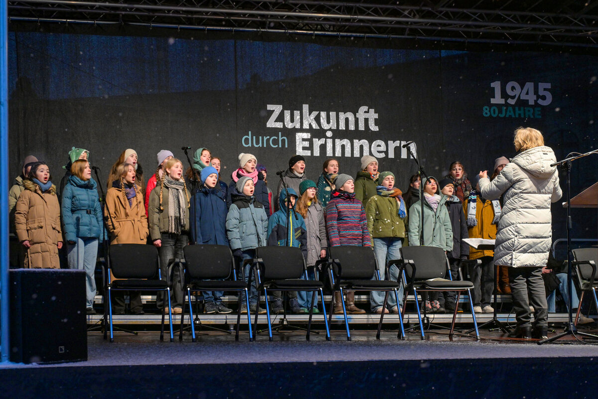 Kinder und Jugendliche stehen auf einer Bühne und singen