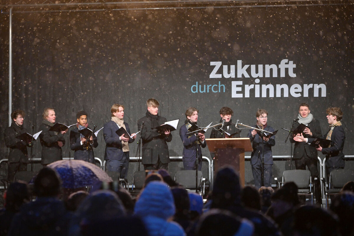 Mehrere Jugendliche stehen gemeinsam auf einer Bühne und singen