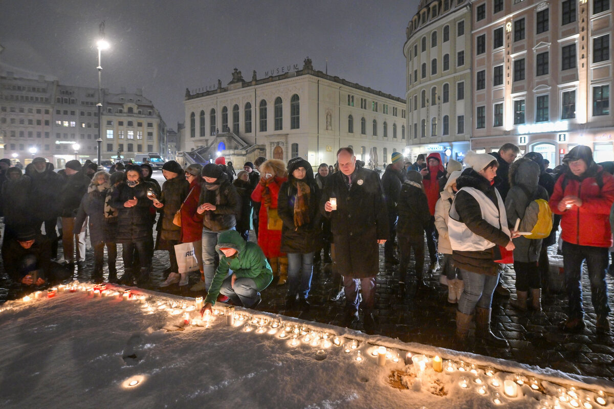 Menschen stellen Kerzen zum Gedenken ab