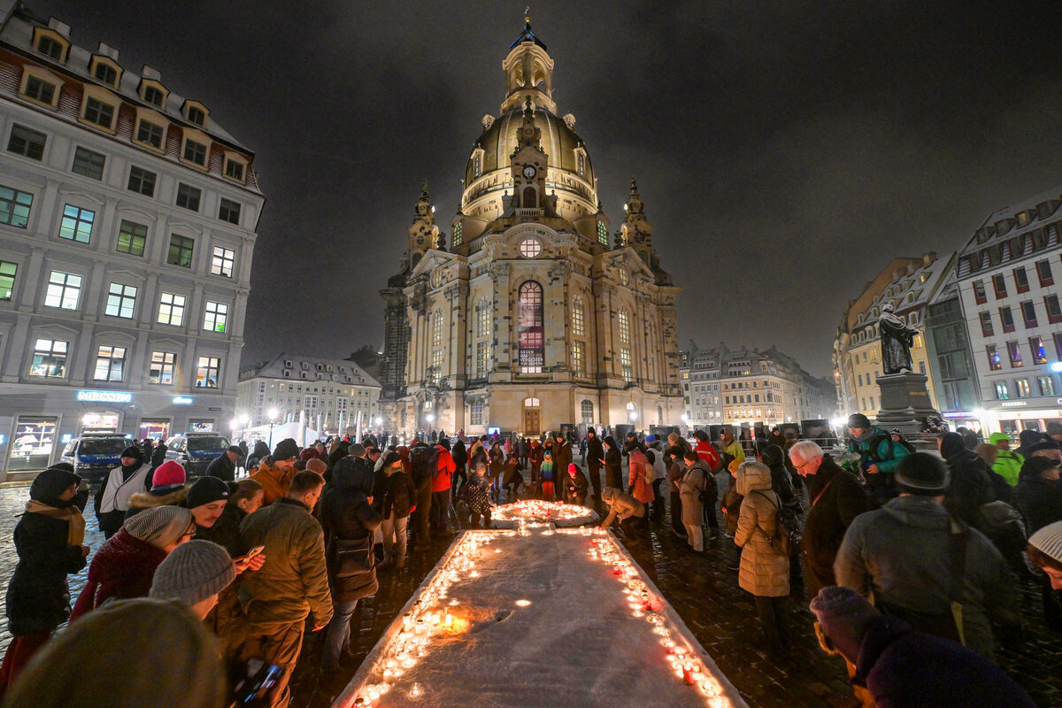 Menschen stellen Kerzen zum Gedenken ab