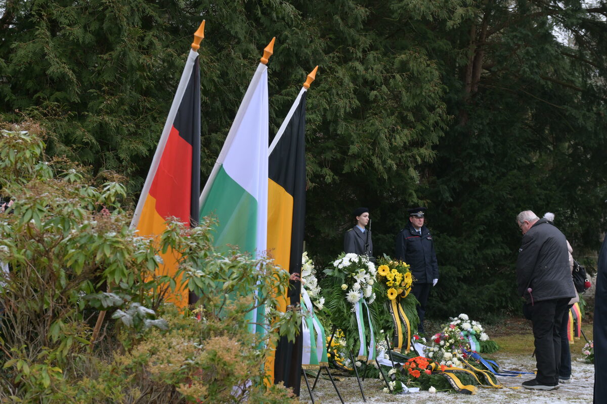 Menschen bei der Kranzniederlegung auf dem Heidefriedhof