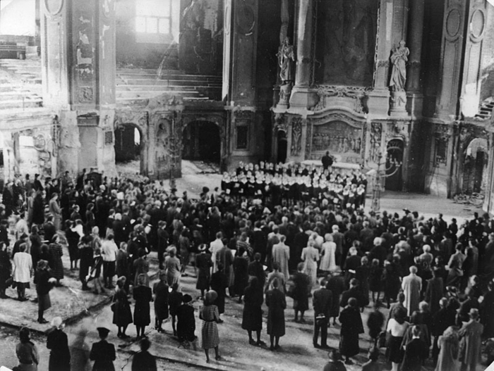 Chor und stehende Zuhörer in der beschädigten Kirche Chor und stehende Zuhörer in der beschädigten Kirche